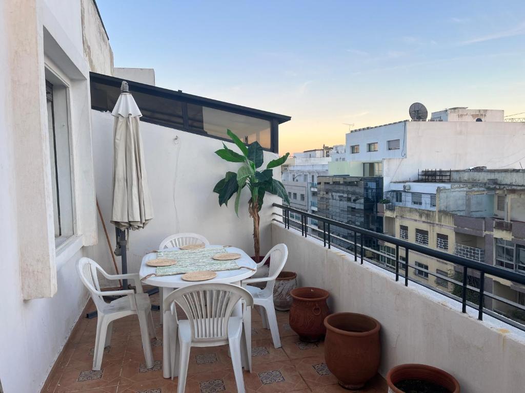 d'une terrasse avec une table et des chaises sur un balcon. dans l'établissement Appart central avec terrasse, à Tanger