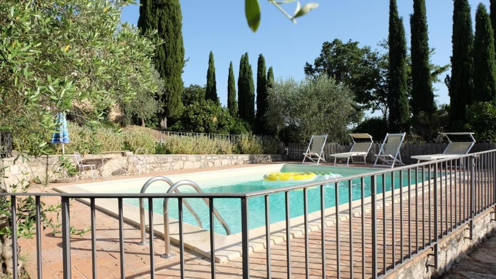 - une piscine avec 2 chaises et une clôture dans l'établissement La Casetta, à Pievina