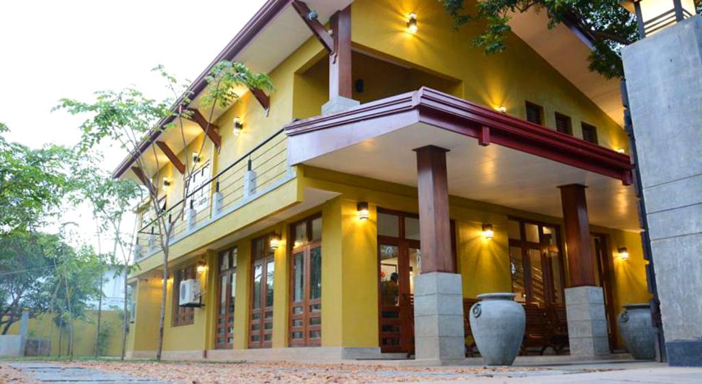 un gran edificio amarillo con muchas ventanas en Inlak Garden Hotel en Negombo