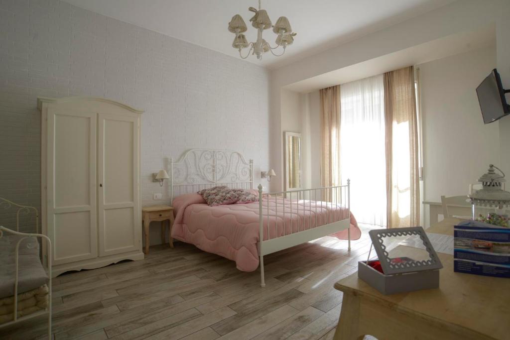 1 dormitorio con cama rosa y ventana en Romantica Salerno, en Salerno