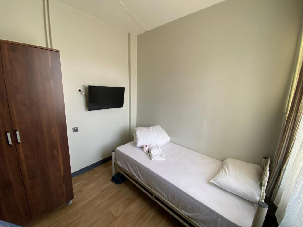 a small room with a bed and a tv at Ferah Hostel in Istanbul