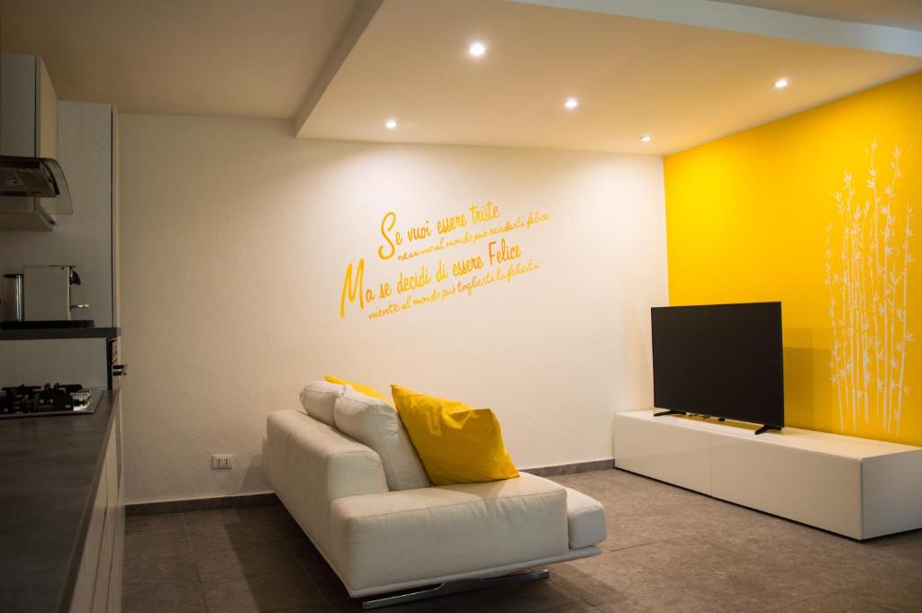 a living room with a white couch and a tv at Il nido di Marty in Issogne