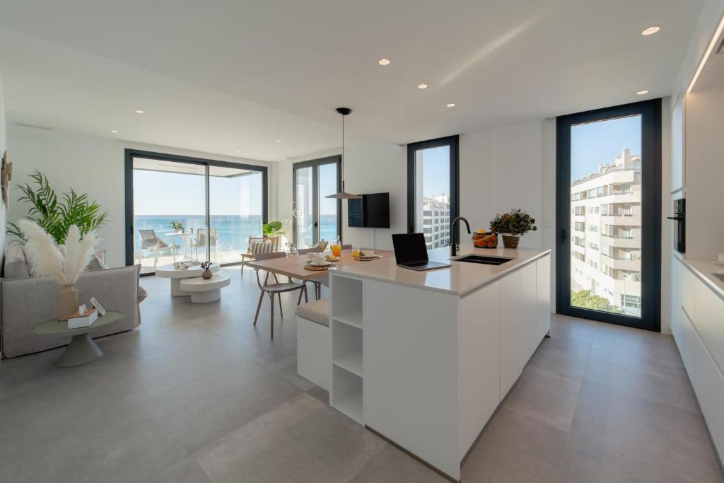 a white kitchen with a table and a dining room at Horizonte Line in Villajoyosa