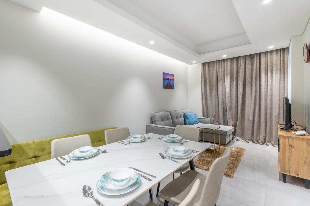 a dining room with a white table and chairs at SuperHost - Comfort 1BR Centurion Onyx Retreat with Balcony in Dubai