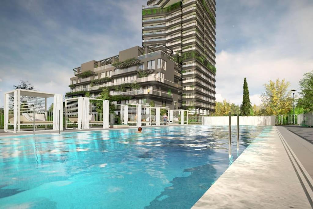 a large swimming pool in front of a tall building at Apartamento Torre Australis in Madrid