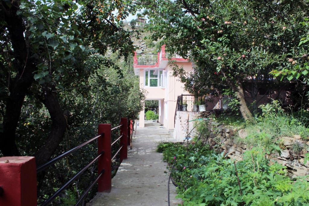 un chemin menant à une maison avec une clôture rouge dans l'établissement THE BLISS HOME STAY, à Kalpa