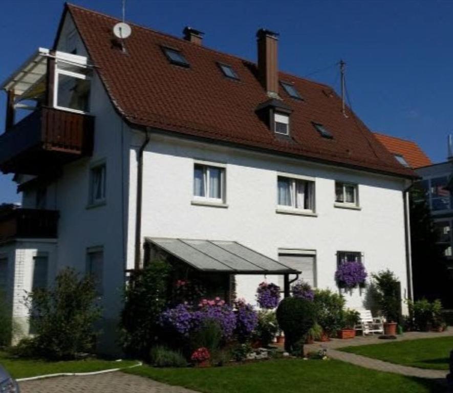 una gran casa blanca con techo rojo en Ferienwohnungen Michael u Christine, en Langenargen