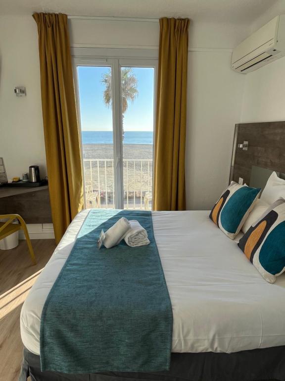 Schlafzimmer mit einem großen Bett und Meerblick in der Unterkunft Hotel Saint Georges, Face à la mer in Canet-en-Roussillon