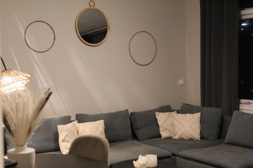 uma sala de estar com um sofá e espelhos na parede em Stads charme & comfort Tilburg em Tilburg