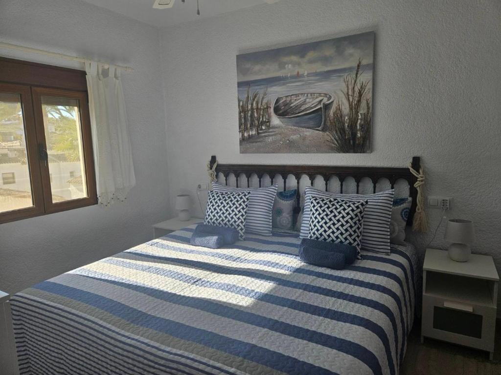 um quarto com uma cama com almofadas azuis e brancas em Villa Adriana v rezidencii Toscamar em Xàbia