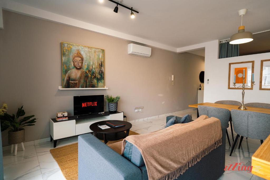uma sala de estar com um sofá e uma televisão em A Stylishly Chic Holiday Home with SOFA BED - A12 em St. Paul's Bay