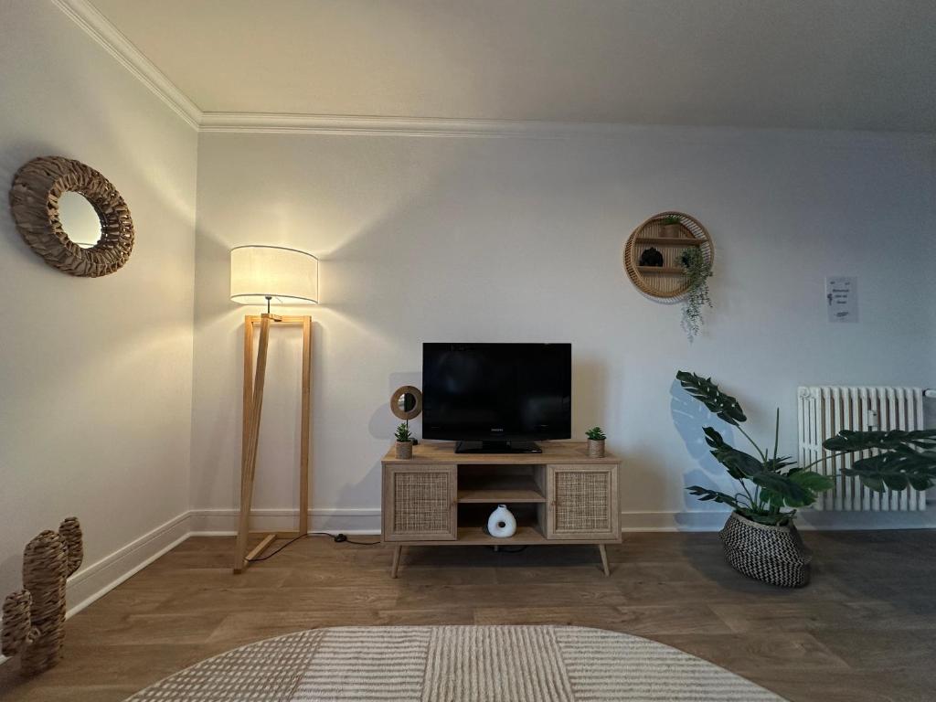 ein Wohnzimmer mit einem Flachbild-TV auf einem Tisch in der Unterkunft Appartement NEUF et cosy à Blois in Blois