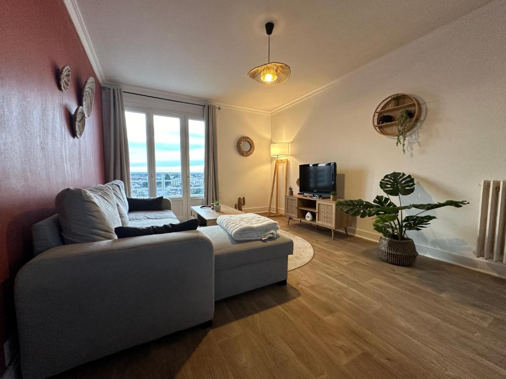 ein Wohnzimmer mit einem Sofa und einem TV in der Unterkunft Appartement NEUF et cosy à Blois in Blois