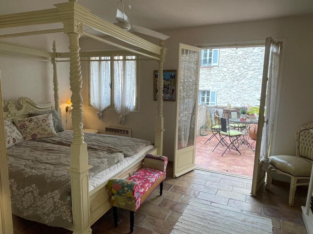 a bedroom with a canopy bed and a chair at Ma Maison in Vence