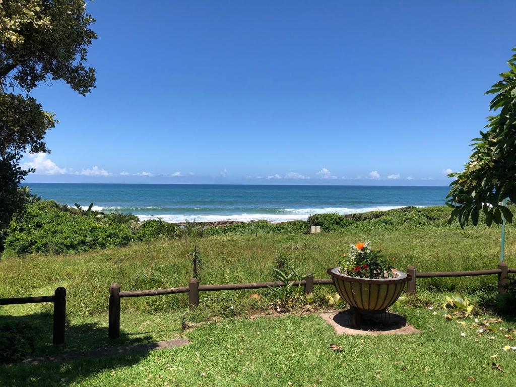 una cerca con una maceta frente a la playa en Scottburgh beach house, en Scottburgh