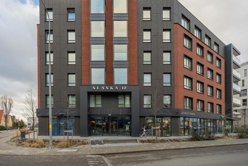 a large brick building with a sign on it at Gdańsk Przymorze Pretty Studios & Pets Allowed by Renters in Gdańsk