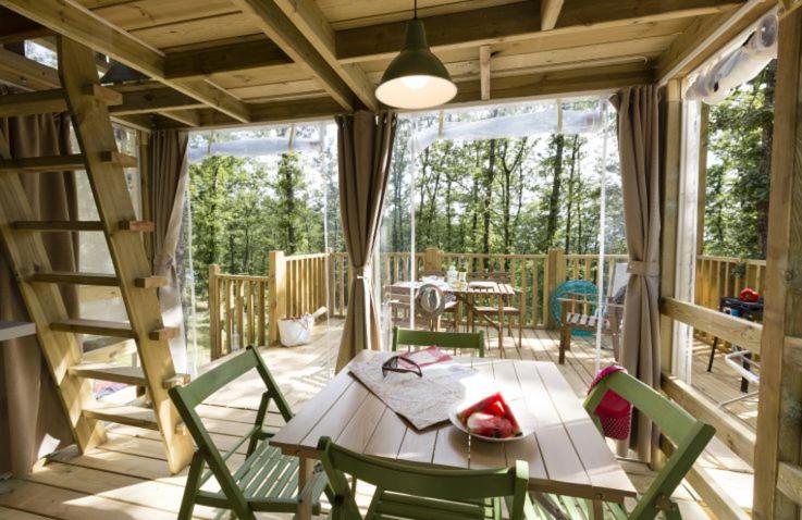 a dining room with a table and chairs on a deck at Drago Tours LODGE TENT Holiday Sunshine, Lanterna in Poreč