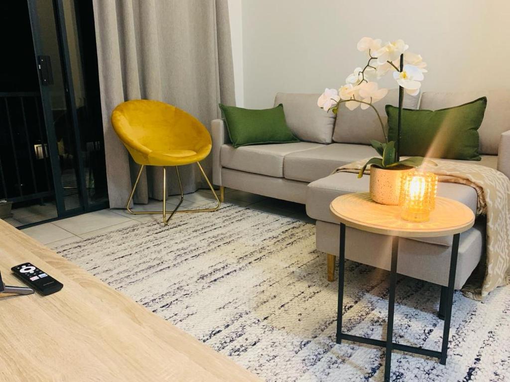 a living room with a couch and a table at Nelly`s Green Creek Luxury Apartment in Pretoria