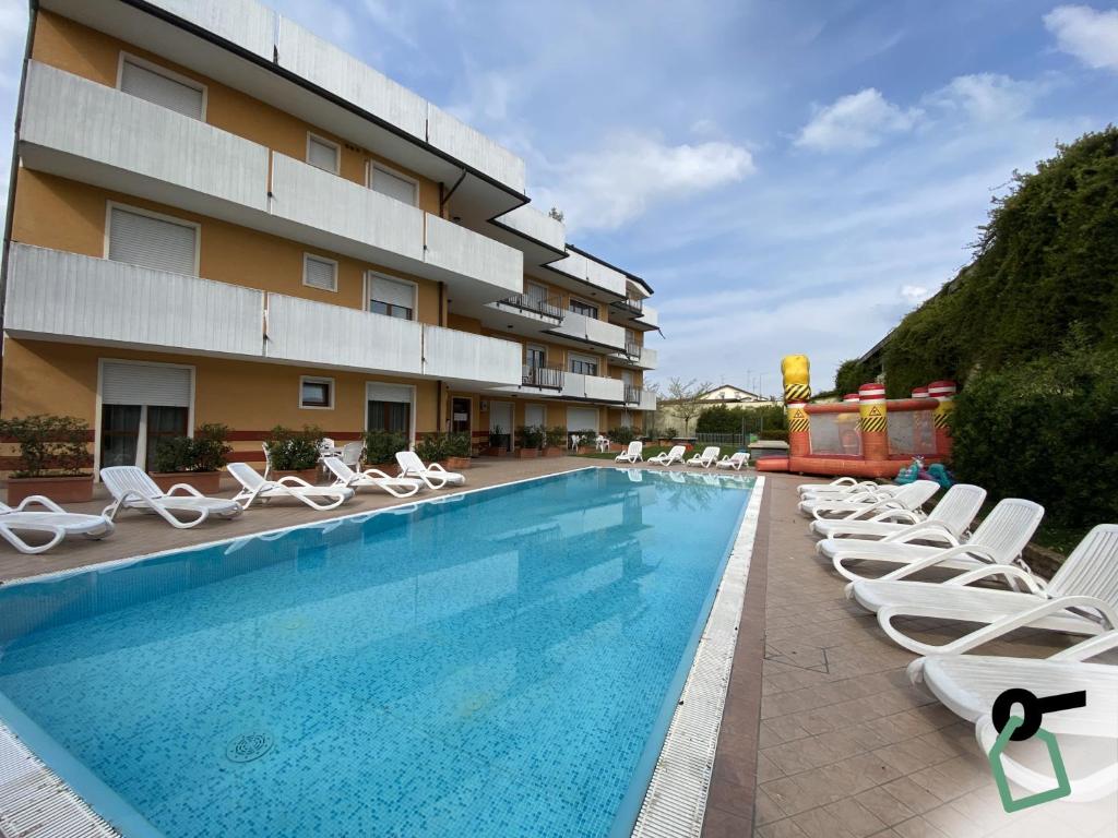 a hotel with a swimming pool with lounge chairs at HOTIDAY Residence Garda in Peschiera del Garda