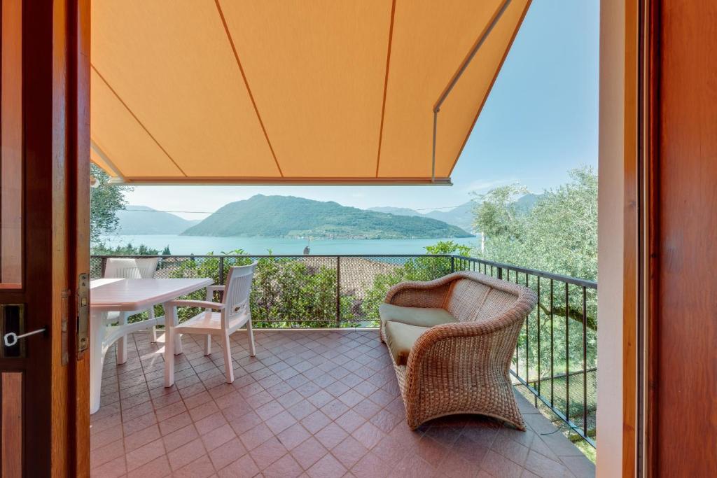 a balcony with a table and chairs and a view of the ocean at Villa Olivella in Sale Marasino
