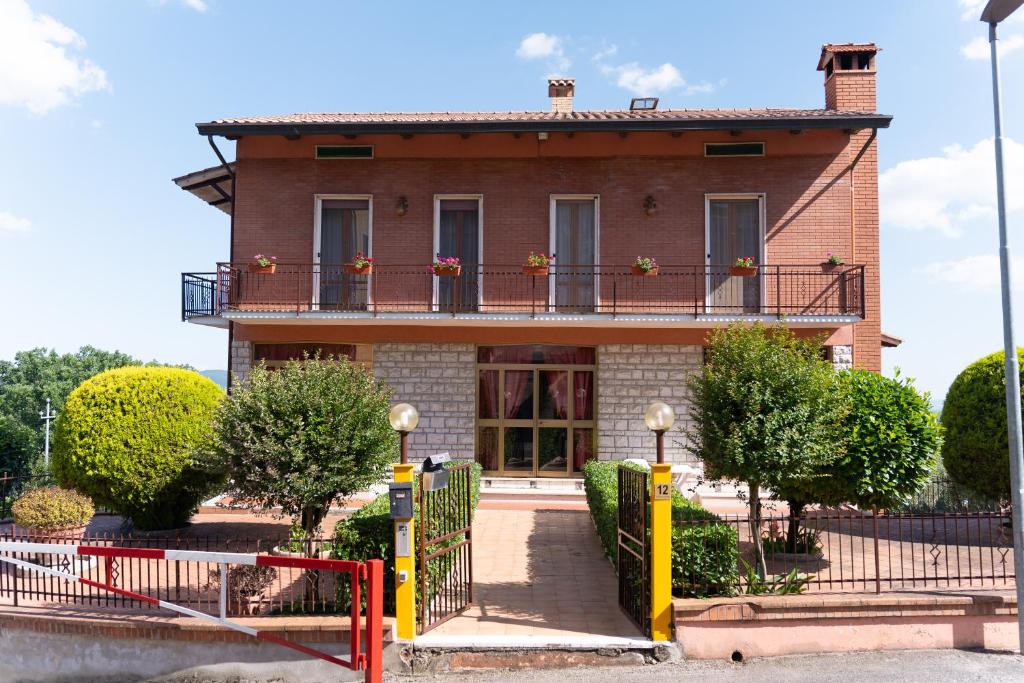 a large brick house with a balcony and trees at Casa Pitara - apartment in vila in San Martino in Colle