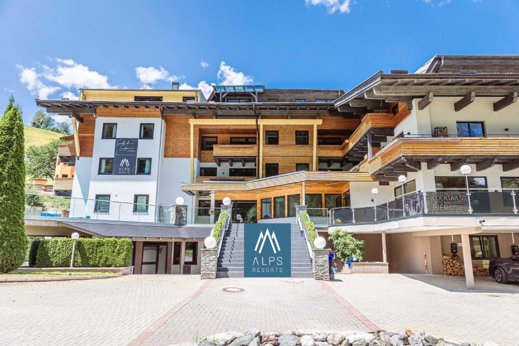 un gran edificio con un cartel delante en Saalbach Suites by ALPS RESORTS en Saalbach Hinterglemm