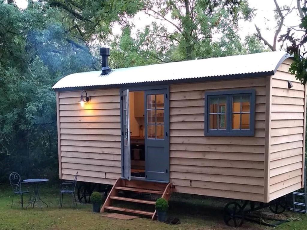una casa pequeña con un porche en un patio en Finest Retreats - The Bakers Hut en Ashurst