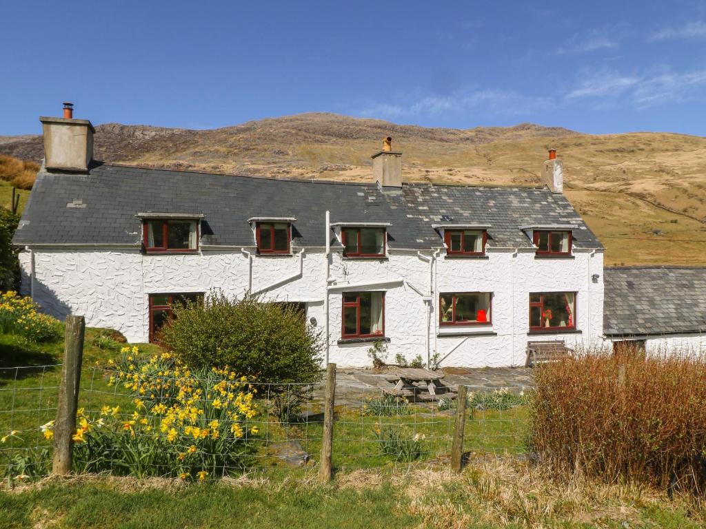 a white house with a hill in the background at Cwm in Betws-y-coed