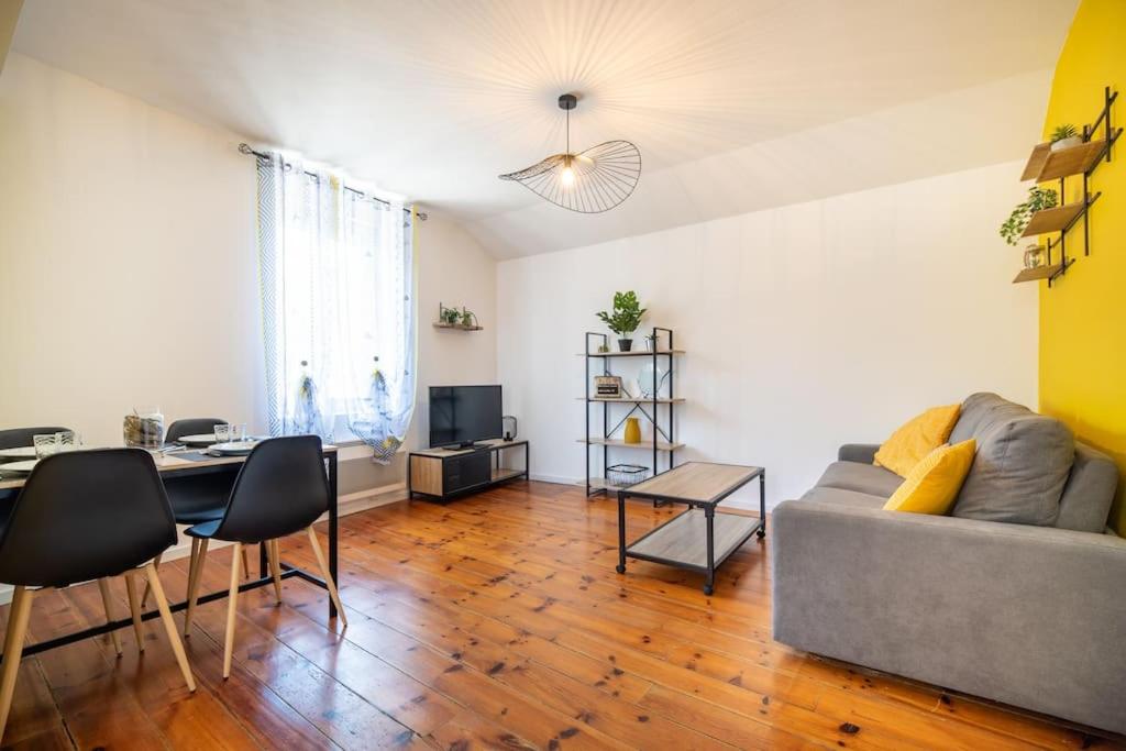 ein Wohnzimmer mit Sofa und Tisch in der Unterkunft L'industriel - Lourdes Centre in Lourdes