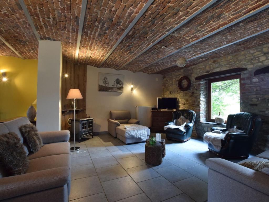 a living room with couches and a stone wall at Libramont Stone Garden Haven in Libramont