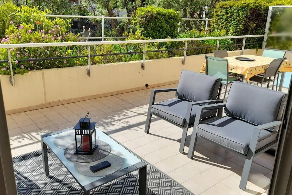 un patio avec deux chaises et une table sur un balcon dans l'établissement En toute quiétude, Fréjus plage à 5min à pied, à Fréjus