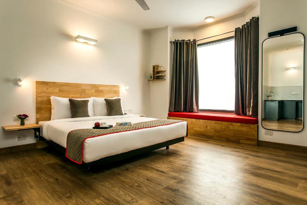 a bedroom with a large bed and a large window at Hotel Belwod INN Near Delhi International Airport in New Delhi