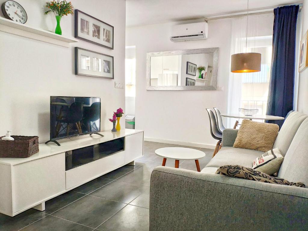 a living room with a couch and a tv at App Coral con AA y Wi-Fi en Vinaròs cerca del mar in Vinaròs