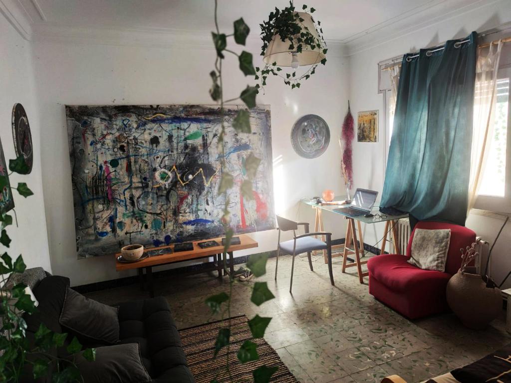 una sala de estar con una mesa y una pintura en la pared en ArtStudio Single, en Manresa