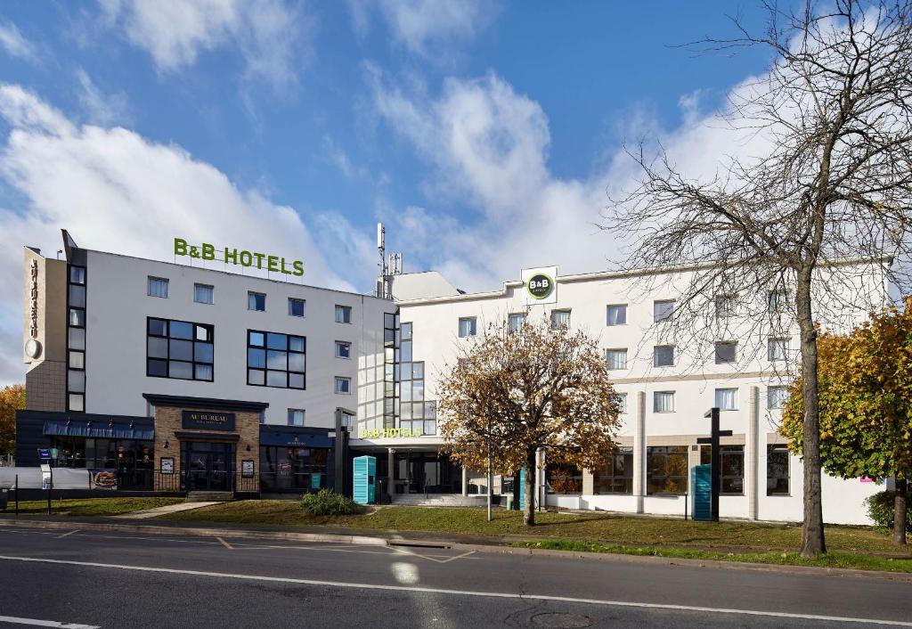 un grand bâtiment blanc avec un panneau indiquant les grands hôtels dans l'établissement B&B HOTEL Paris Rosny-sous-Bois, à Rosny-sous-Bois