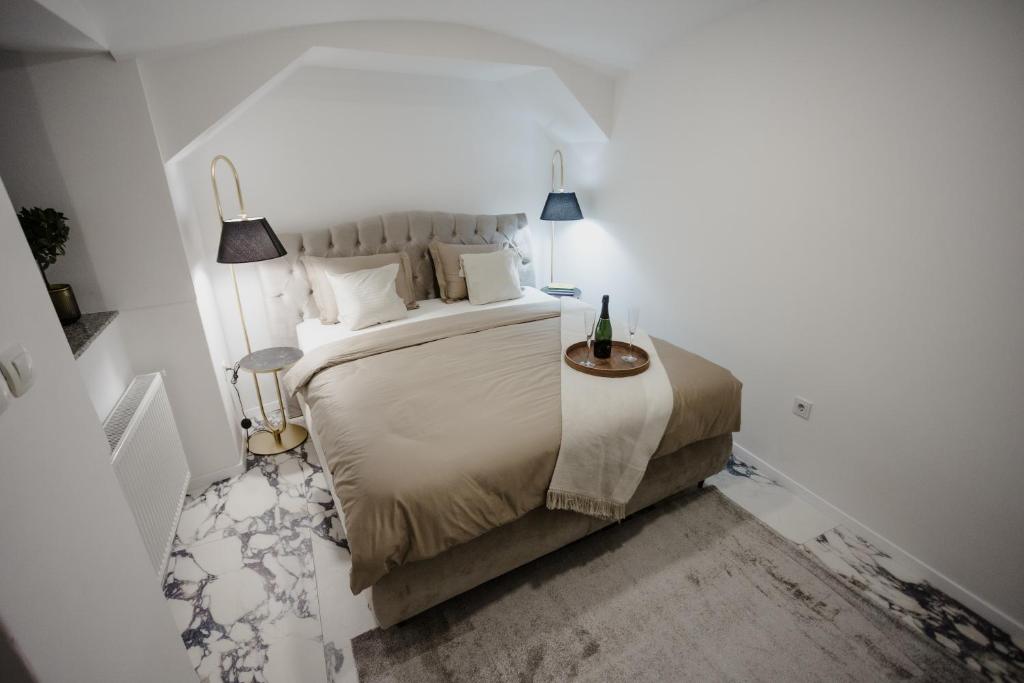 a white bedroom with a large bed and two lamps at AMORE LUXURY APARTMENT in Zagreb