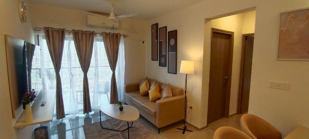 sala de estar con sofá, mesa y ventana en Z Bliss Suites, BKC, en Bombay