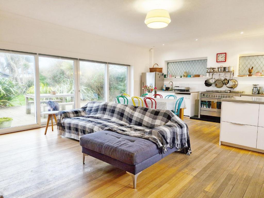 a living room with a couch and a kitchen at Coastal - Wittering in West Wittering