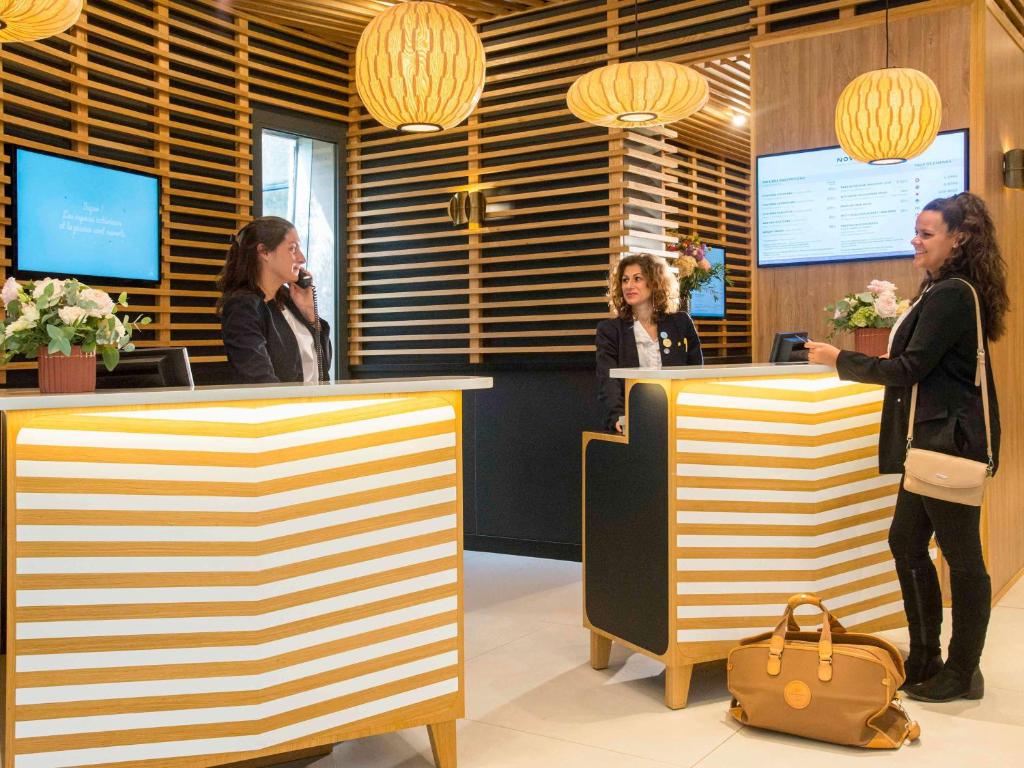 a group of women standing at a reception desk at Novotel Nice Arenas Aeroport in Nice