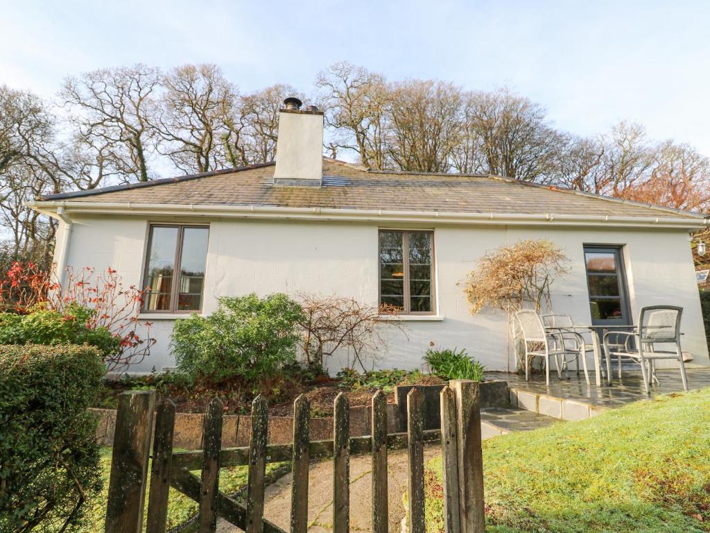 une maison blanche avec une clôture devant elle dans l'établissement Ruan Dinas, à Truro