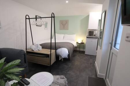 a small bedroom with a bed and a kitchen at The Snug- Studio in Portishead with Parking in Portishead