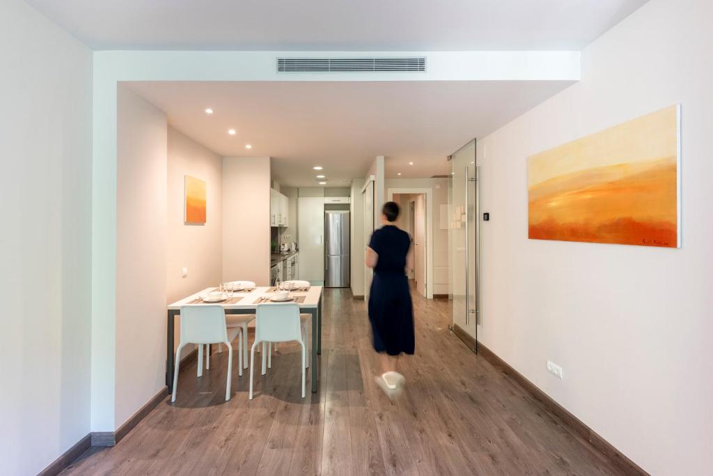 a woman in a black dress is standing in a room at Espais Blaus Apartments in Barcelona