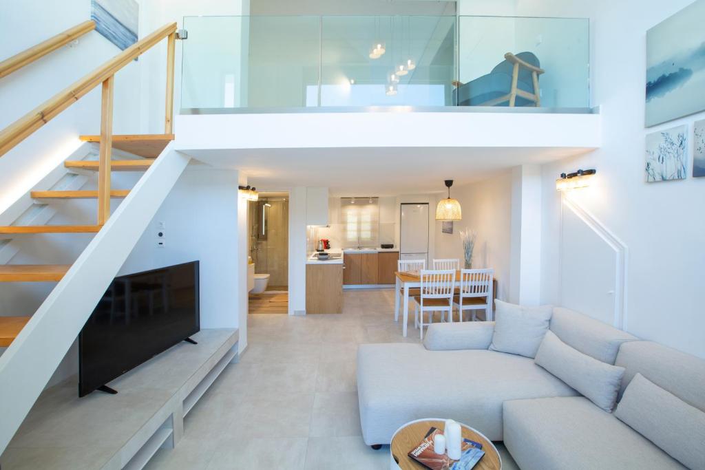 a living room with a couch and a staircase at Insieme Lefkada Maisonettes in Vlikhon