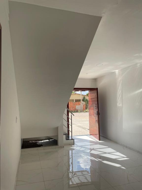 a white hallway with a staircase and a door at AP Locação de Diárias Lajes/RN in Lajes