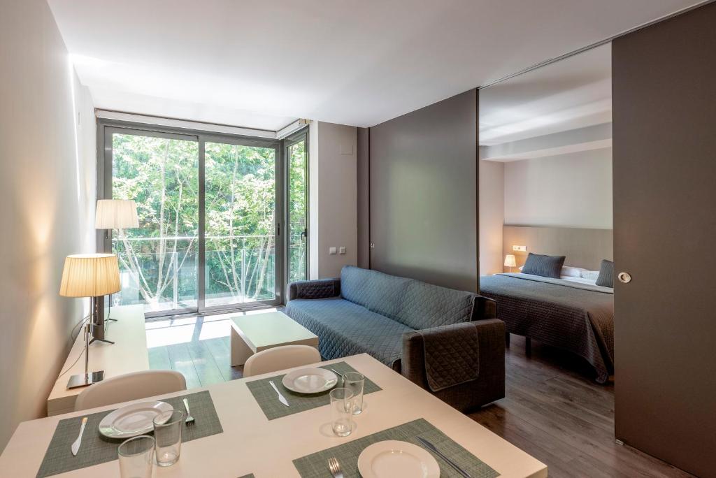sala de estar con sofá y habitación con cama en Espais Blaus Apartments, en Barcelona