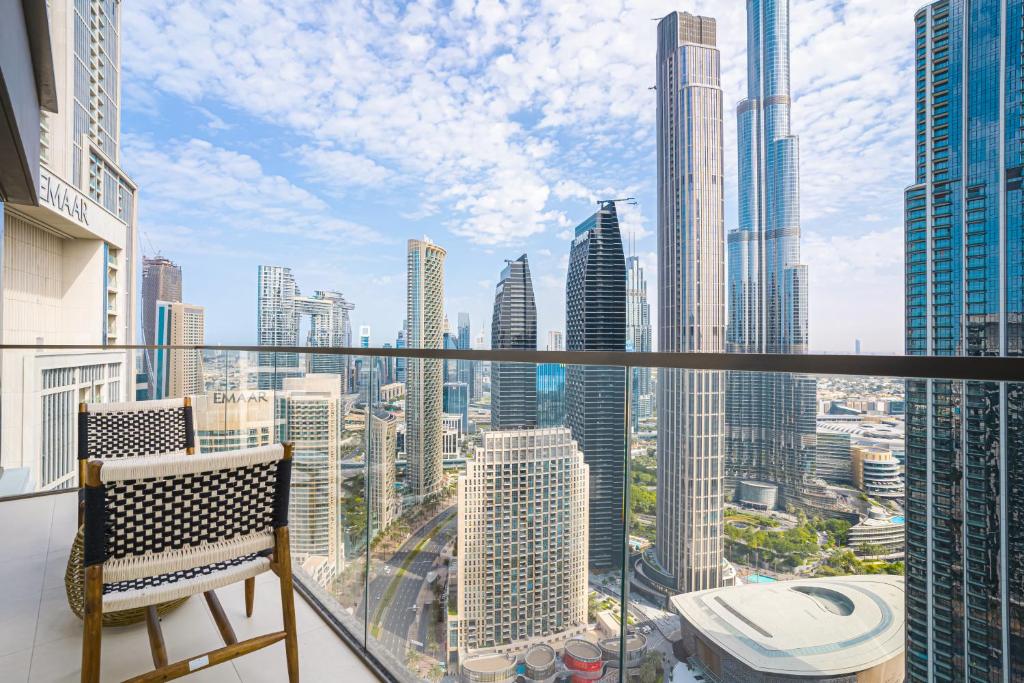 Top Floor Apartment with Burj Khalifa Views and Full Downtown Views171BC-2 في دبي: بلكونه فيها كرسي واطلاله على مدينه