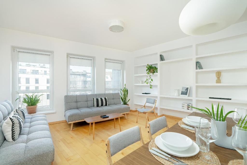 a living room with a couch and a table at Spacious & Bright Apartment with Parking Poznań by Renters in Poznań