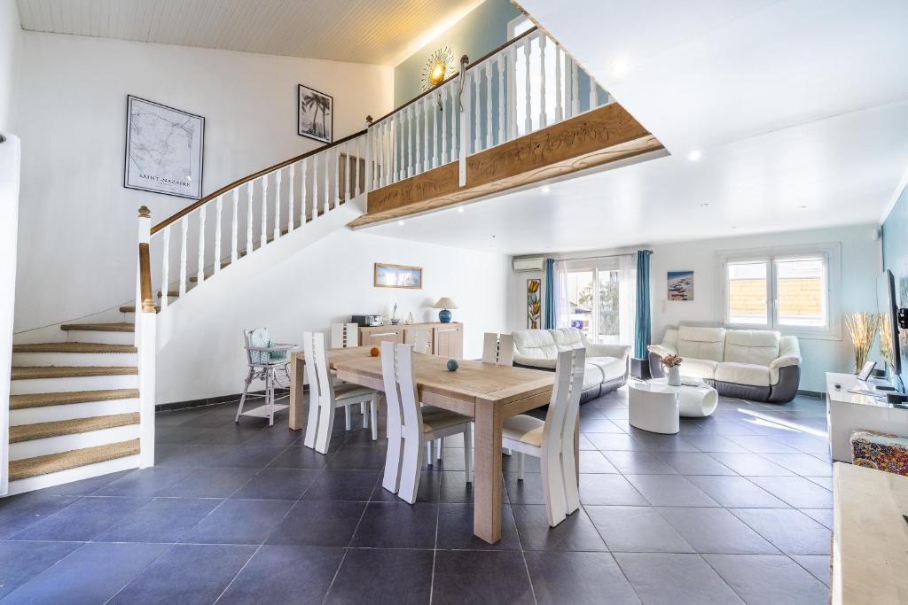 une salle à manger et un salon avec une table et des chaises dans l'établissement La maison de Parrain - A proximité des plages, à Saint-Nazaire