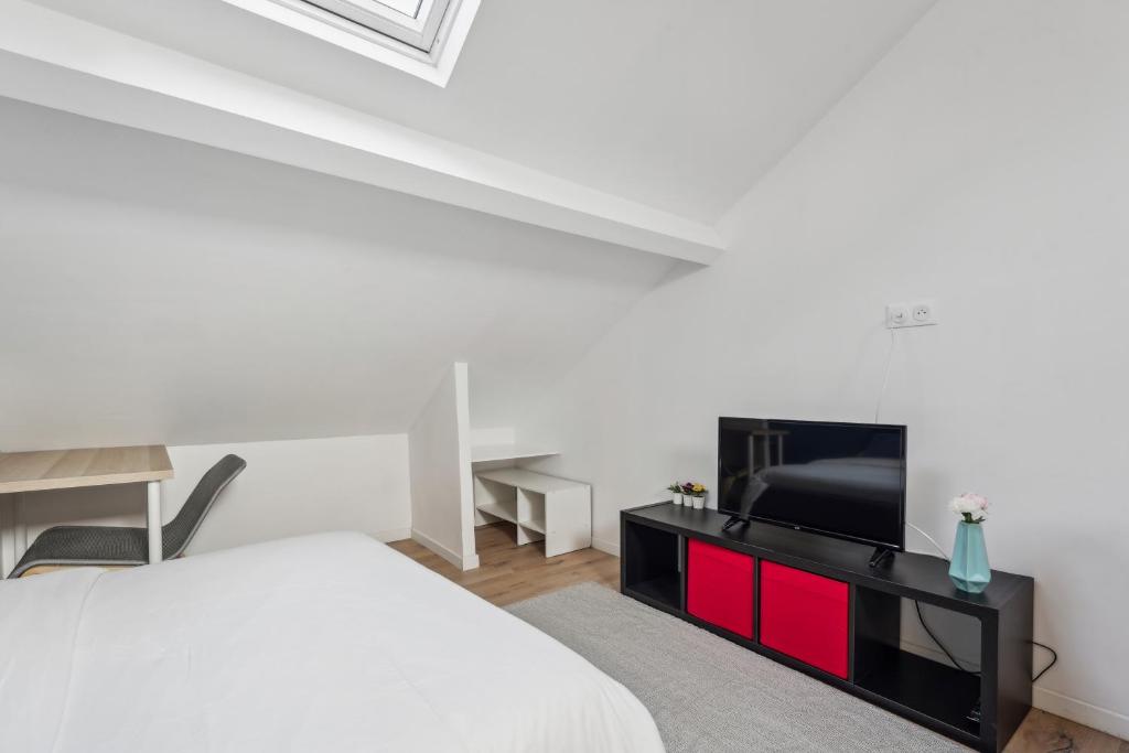 une chambre avec un lit et une télévision à écran plat dans l'établissement Budget appart avec parking au centre-ville, à Charleville-Mézières