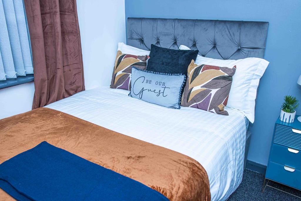 1 dormitorio con cama con almohada en TD M-Gold Dudley Luxurious 3 Bedroom House - Sleeps 8 - Perfect for Leisure, Families, Business Long and Short Stay - Free Parking 